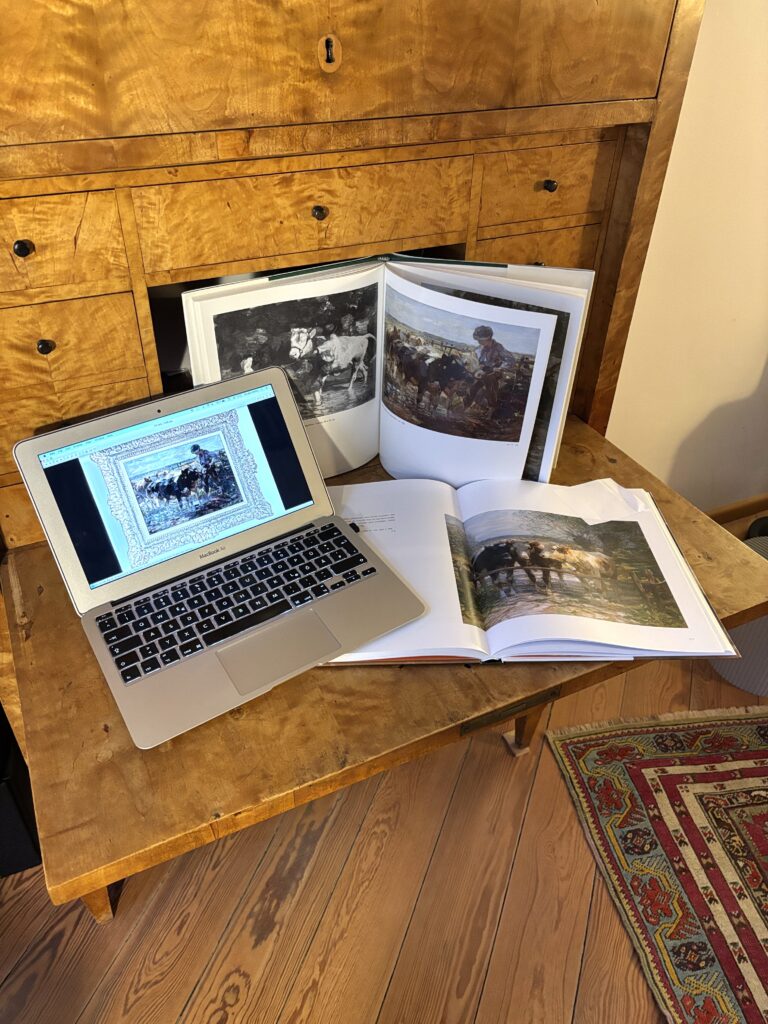 Bücher und Laptop auf Tisch zur kunsthistorischen Recherche für Kunstgutachten von Gemälden und Antiquitäten in München